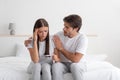 Sad unhappy young caucasian husband calm his wife on bed, lady look at pregnancy test in bedroom Royalty Free Stock Photo