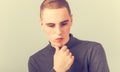 Sad unhappy young man thinking with hand under the face and looking down. Vintage closeup portrait Royalty Free Stock Photo