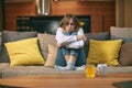 Sad unhealthy young woman suffering from freezing, caught cold, treating alone at home sitting on sofa hugging herself Royalty Free Stock Photo