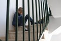 Sad upset boy sitting on stairs, covering his face. Negative emotion, depression, stress, school bullying concept Royalty Free Stock Photo