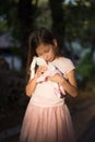 Sad upset Caucasian girl hugging toy. Child embrace soft plush bear in park outdoors. Lost lonely child kid outside Royalty Free Stock Photo