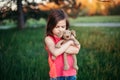 Sad upset Caucasian girl hugging toy. Child embrace soft plush bear in park outdoor. Lost lonely child kid outside. Unhappy Royalty Free Stock Photo