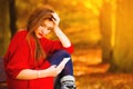 Sad upset girl with mobile phone in autumn park Royalty Free Stock Photo