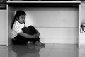 Sad upset unhappy boy kid hiding under the table.