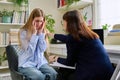 Sad upset young teenage female patient talking to professional mental therapist Royalty Free Stock Photo