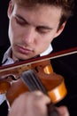 Sad violinist playing a violin on a dark background, close-up portrait on an isolated background Royalty Free Stock Photo