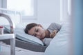 Sad and weak girl lying alone in the hospital bed Royalty Free Stock Photo