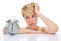 Sad woman, alarm clock and headache from alert, wakeup or deadline on a white studio background. Frustrated female