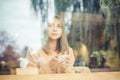 Sad woman alone in a lonely bar after a break up thinking with a rainy day reflection outdoor in the background Royalty Free Stock Photo