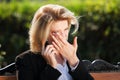 Sad business woman calling on cell phone in city park Royalty Free Stock Photo