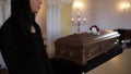 Sad woman and coffin at funeral in church
