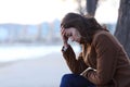 Sad woman complaining on a bench in winter on the beach Royalty Free Stock Photo