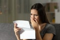 Sad woman complaining reading a letter in the night Royalty Free Stock Photo