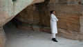 Sad woman contemplating problems hiding at seashore rock. Pensive model resting