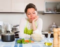 Sad woman cooking rice in the kitchen