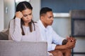 Sad, woman and couple in unhappy marriage from argument, fight or disagreement on living room sofa at home. Upset female