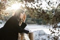 Sad woman dressed in black watching the sea with the sunset on the background Royalty Free Stock Photo