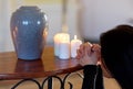 Sad woman with funerary urn praying at church Royalty Free Stock Photo