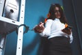 Sad woman handcuffed in office. Young businesswoman with note stickies uses mobile phone while locking. Lock down Royalty Free Stock Photo