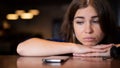 The sad woman has laid her head on the table and is waiting for a phone call Royalty Free Stock Photo