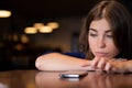 The sad woman has laid her head on the table and is waiting for a phone call Royalty Free Stock Photo