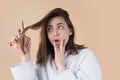 Sad woman having her hair cut with scissors. Beautiful woman in panic because of hair loss. Woman with hair loss problem Royalty Free Stock Photo