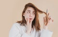 Sad woman having her hair cut with scissors. Beautiful woman in panic because of hair loss. Woman with hair loss problem Royalty Free Stock Photo