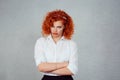 Sad woman. Headshot of young business lady red head girl ginger hair curly isolated on gray background wall