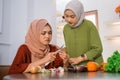 sad woman in hijab peeling onions and her friend sympathizing Royalty Free Stock Photo