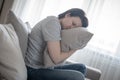 Sad woman at home sitting on sofa and hugging a pillow, loneliness and sadness concept Royalty Free Stock Photo