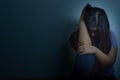 sad woman hug her knee and cry sitting alone in a dark room. Depression, unhappy, stressed and anxiety disorder concept Royalty Free Stock Photo