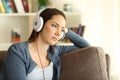 Sad woman listening to music at home