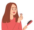 Sad woman looking at hairbrush with strands of hair Royalty Free Stock Photo