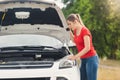Sad woman looking at the motor of broken car and waiting for help Royalty Free Stock Photo