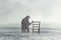 Sad woman looking nostalgically at her lover`s empty chair Royalty Free Stock Photo