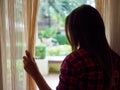 Sad Woman looking out a window, indoors.