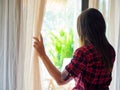 Sad Woman looking out a window, indoors.