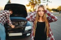 Sad woman, man against open hood on the background Royalty Free Stock Photo