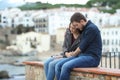 Sad woman and man comforting her on a ledge
