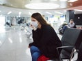 sad woman in medical mask waiting airport flight delay