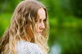 Sad young fashion woman with long curly hairs outdoor