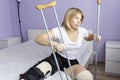 Sad woman after an operation on her leg is sitting on the bed Royalty Free Stock Photo