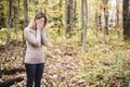 A Sad woman in park during autumn weather hiding face in hand, feeling terrible depressed.