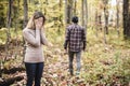 A Sad woman in park during autumn weather hiding face in hand, feeling terrible depressed.