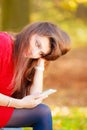 Sad woman in park with phone. Royalty Free Stock Photo