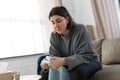 sad woman popping bubble wrap at home