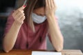 Sad woman in protective mask holding wedding ring in her hand Royalty Free Stock Photo