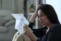 Sad woman reading a letter alone at home Royalty Free Stock Photo