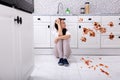 Sad Woman Sitting In Dirty Kitchen Royalty Free Stock Photo