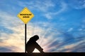 Sad woman sitting in front of a road sign menopause ahead.